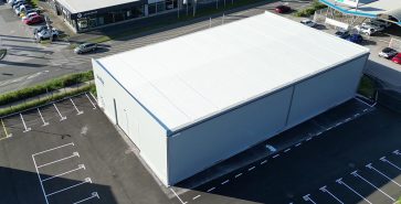 Blick auf modernes Flachdach-Lager auf Asphaltfläche